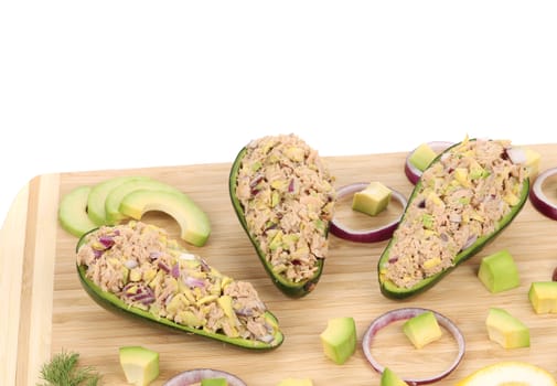 Avocado salad with tuna. Located on the wooden hardboard.