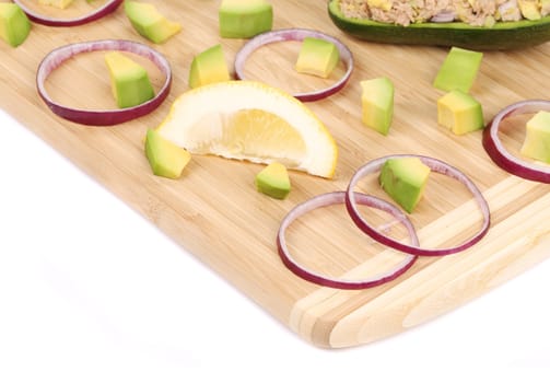 Avocado salad with tuna. Located on the wooden hardboard.