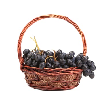 Red grapes in wicker basket. Isolated on a white background.