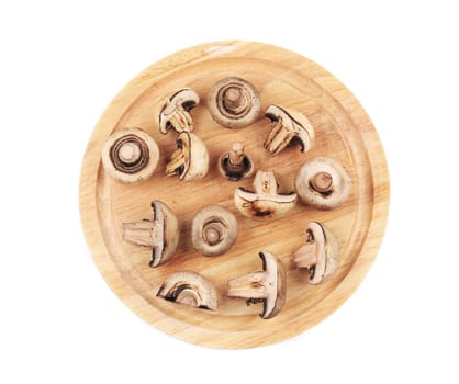 Mushrooms on wooden platter. Isolated on a white background.