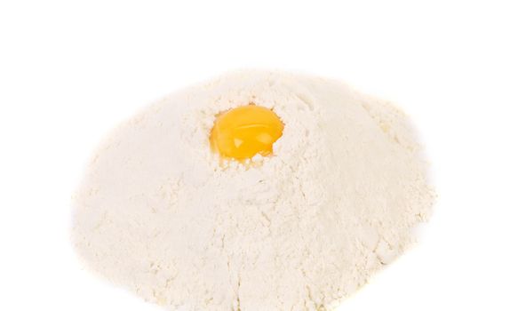 Yellow raw yolk on flour. Isolated on a white background.