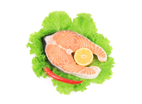 Fresh salmon steak on salad leaf. Isolated on a white background.