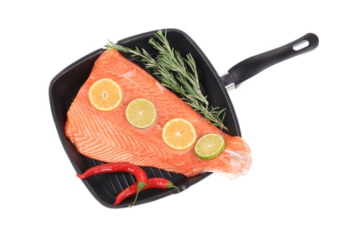 Raw salmon on frying pan with rosemary. Isolated on a white background.