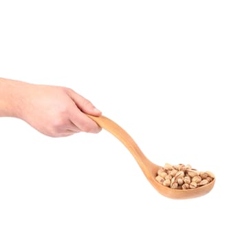 Hand holding spoon with pistachios. Isolated on a white background.