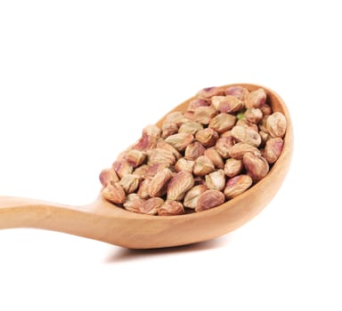 Wooden spoon with pistachios. Isolated on a white background.