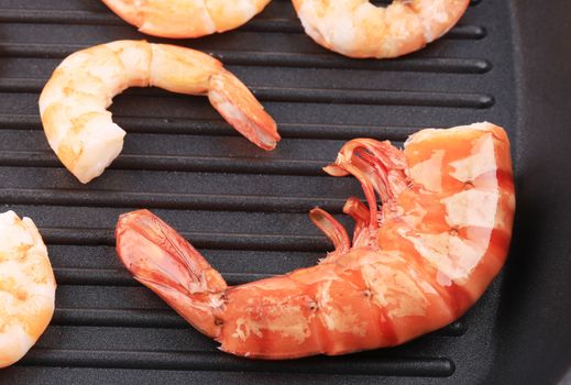 Cooked unshelled shrimps on frying pan. Whole background.