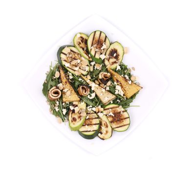 Salad with grilled vegetables and tofu. Isolated on a white background.