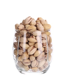 Water glass full of pistachios. Isolated on a white background.