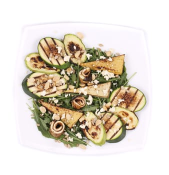 Salad with grilled vegetables and tofu. Isolated on a white background.