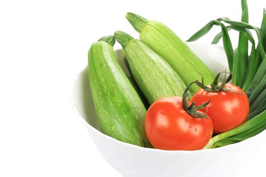 Courgettes, spring onions and tomatoes. Isolated on a white background.