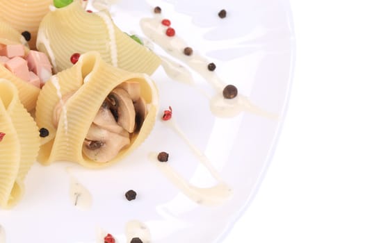 Italian pasta lumaconi with mushrooms. Isolated on a white background.