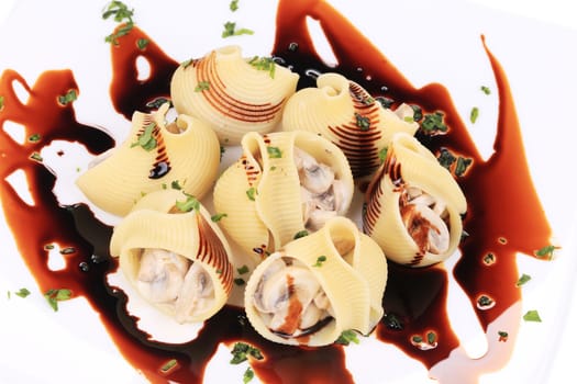 Lumaconi pasta with mushroom sauce. Isolated on a white background.