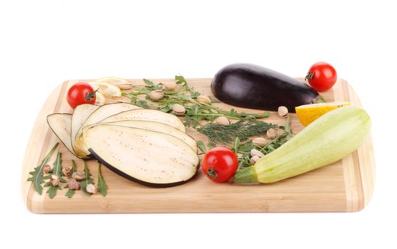 Vegetables on wooden board. Isolated on a white background.