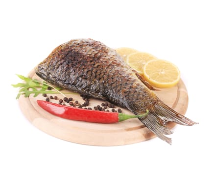 Fried carp with lemon and parsley. Isolated on a white background.