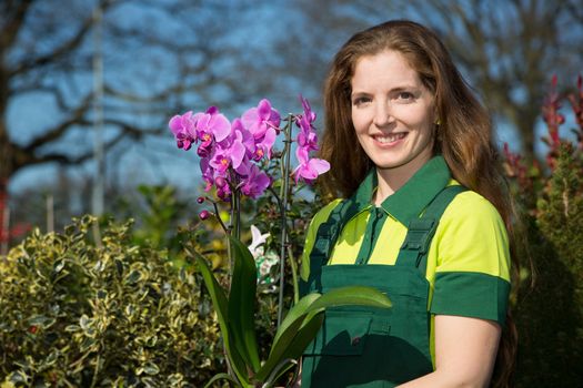Florist or gardener posing with orchid flower
