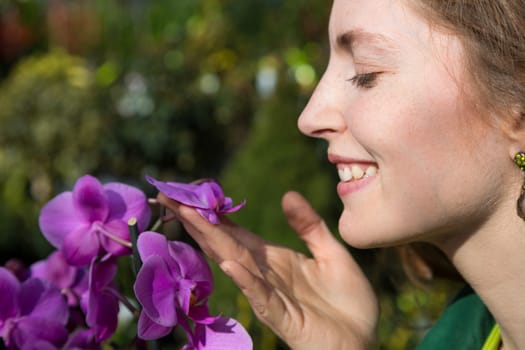 Woman smelling at beautiful orchid flower