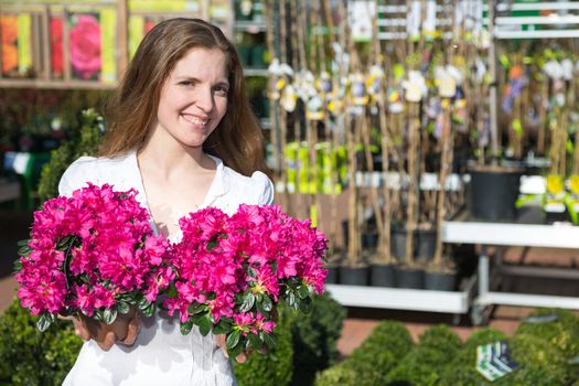 Customer at garden center or flower shop posing with a bunch of flowers 
