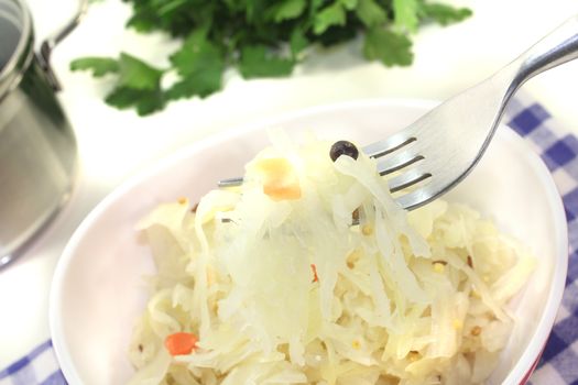 Sauerkraut on a fork before light background