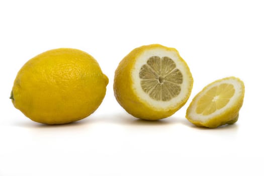 whole and sliced ​​lemons on a white background