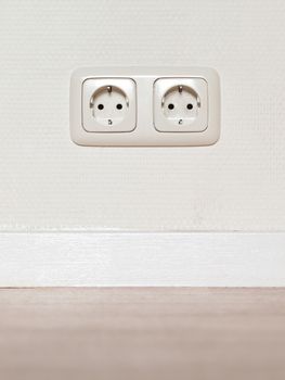 Electrical jack white plastic socket on a white wall