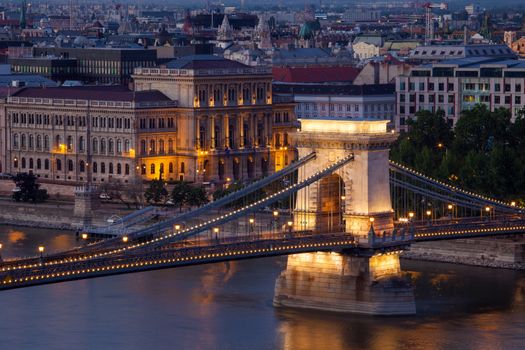 Budapest sunset cityscape with Chain Bridge in front over Danube river and Parliament Building in the background.