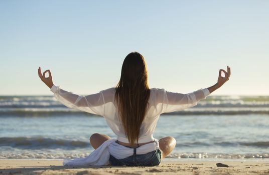 woman doing yoga on a beach