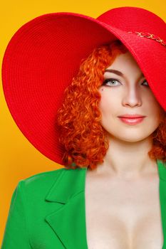 Attractive red-haired girl in red shady hat shot closeup