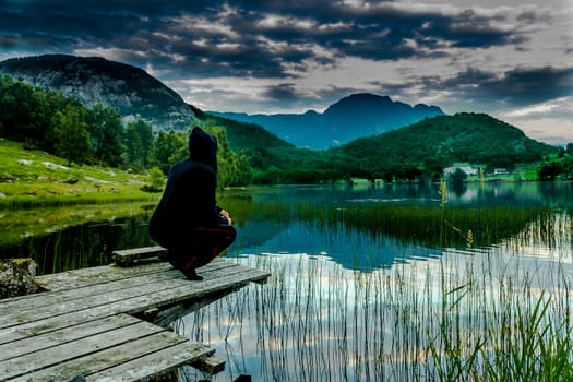 a boy staring at the lake and mountain