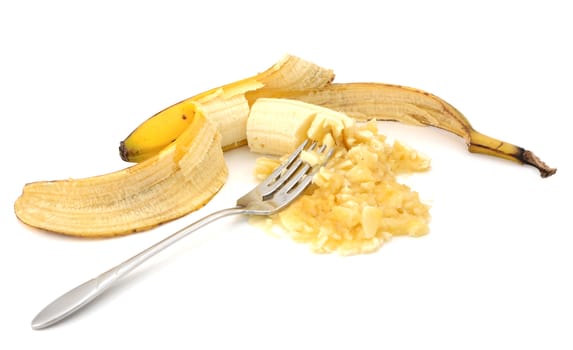 Mashing a peeled overripe banana with a fork, isolated on a white background