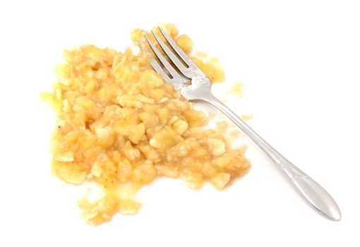 Mashed banana flesh with a fork, isolated on a white background