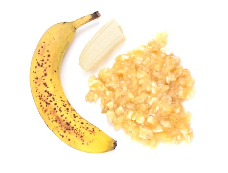 Spotty, overripe banana with whole and mashed fruit, isolated on a white background
