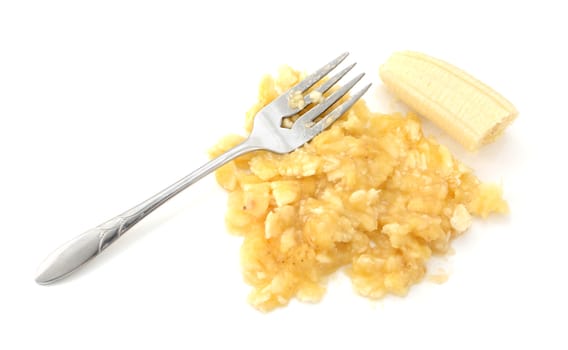 Ripe banana being mashed with a fork, isolated on a white background