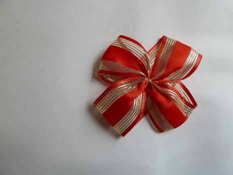 Gold and red ribbon on a plain white background