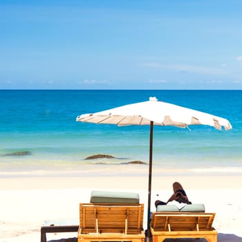 Beach chair and umbrella on sand beach.