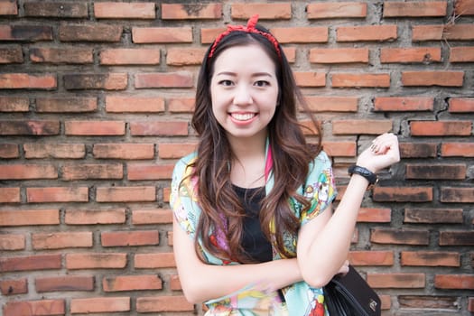 A portrait of beautiful asian woman with brick wall background