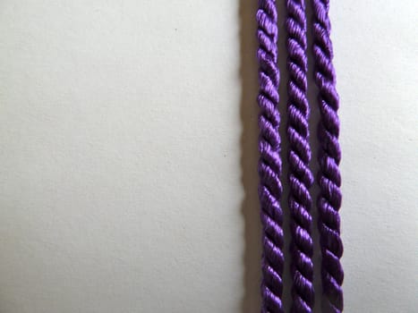Three bright purple lines of cotton rope