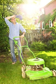 Man taking a break while mowing lawn on hot summer day