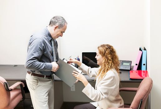 Man and woman meeting to discuss paperwork in office