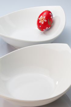 Two white bowls and red easter egg