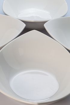 Four empty white ceramics bowls