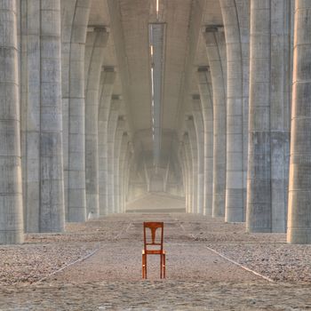 Abandoned chair under the highway bridge at sunrise