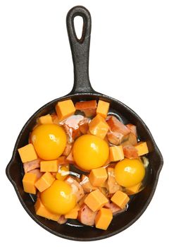 Raw Eggs, Cheese and Sausage in Cast Iron Skillet Isolated Over White.