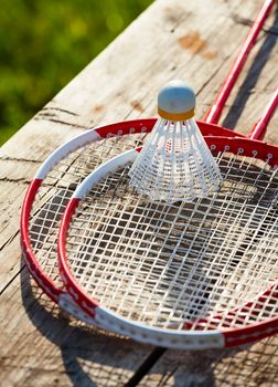 Badminton racquets with shuttlecock on a bench