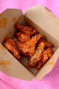 takeout box of spicy buffalo wings and drumsticks