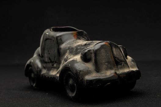 Vintage Old Ceramic Black Car on the Dark background
