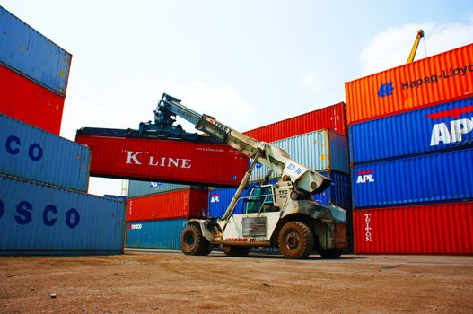 HO CHI MINH CITY, VIET NAM- MAR 19 :  Forklift truck crane container at  freight depot, cargo box in stack, this industrial port is logistic service of import, export  goods ,Vietnam, Mar 19, 2014