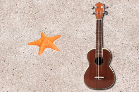 ukulele  and sea orange star on the beach