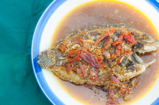 A deep fried fish topped with chili.