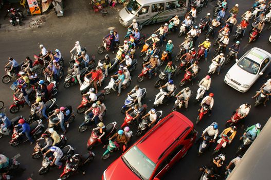 HO CHI MINH CITY, VIET NAM- MAR 27: Dense, crowed  scene of urban traffic  in rush hour, crowd of people wear helmet, ride motorbikes, stop at red light in stress situation, Vietnam, Mar 27, 2014