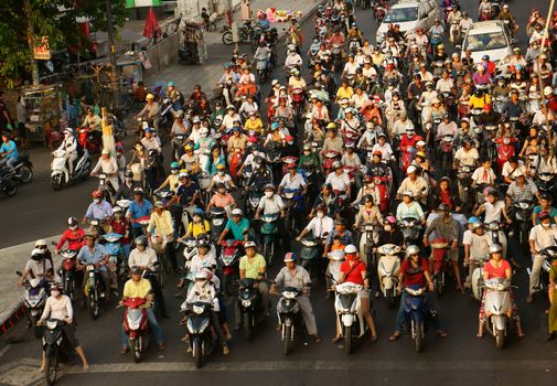 HO CHI MINH CITY, VIET NAM- MAR 27: Amazing, crowed  scene of urban traffic  in rush hour, crowd of people wear helmet, ride motorbike, stop at red light in waiting situation, Vietnam, Mar 27, 2014
